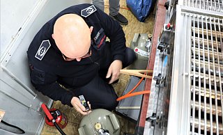 Jürgen Rabbe kontrolliert mit dem Gaswarnmelder in der Hand die angeschlossenen Gasflaschen in einem Imbiss. - Simone Flörke