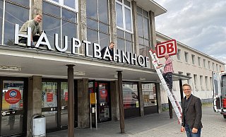 Der Schriftzug des Paderborner Hauptbahnhofs ist nun Museumsreif. Die städtischen Museumstechniker (v. l..) Markus Liebeck, Heiko Henke und Heinrich Schniedermeier sowie Markus Runte vom Stadtmuseum bei der Demontage am Hauptbahnhof. - Stadt Paderborn