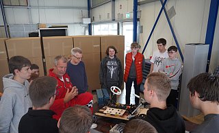 Klaus Meyer von Innovationsnetzwerk Energie Impuls OWL schaut sich den Solarracer einer Schulgruppe an. - Felix Schwien
