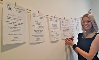 Jana Wieners an der Leine, auf der die unterschiedlichen Angebote für die Kinder verschiedenen Alters aufgereiht sind - Simone Flörke