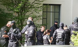 Zahlreiche Einsatzkräfte sind an der Erpestraße zusammengezogen. Darunter auch Beamte einer Beweissicherungseinheit, wie am Kürzel auf der Weste zu erkennen ist. - Paul Brinkmann