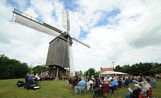 Andacht außerhalb einer Kirche: Unter dem Flügelkreuz der Weher Bockwindmühle feiern die Gläubigen aus der Kirchengemeinde Rahden an Himmelfahrt Gottesdienst. - Joern Spreen-Ledebur