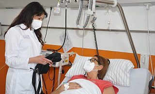 Die Oberäztin Indira Ruch prüft den Schmerzkatheter von Diana Vorthmann. Bei starken Schmerzen kann sich die Patientin per Knopfdruck zusätzliche Medikamente selbst verabreichen. - Brüderkrankenhaus St. Josef