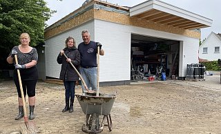 Susanne Konrad (v.l.), Anke und Christian Kirsch versuchen ihren Hof in Hiddenhausen vom Schlamm zu befreien. - Benedikt Riemer