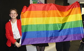 Johanna und Maxim halten die Regenbogenflagge. Maxim wollte unerkannt bleiben. Auch Luisa und ihre Freundin, die sie begeleitet hatte, bleiben hinter der Flagge. - Anastasia von Fugler