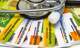 Gesundheitskarten und Stethoskop: Die Zukunft der Krankenkassenbeiträge steht auf dem Prüfstand. - picture alliance / SZ Photo