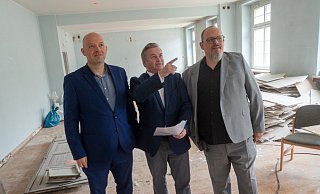 Marcel Haselof (l.), Pascal Görlitz (r,) von der Stadtentwicklungsgesellschaf SEH und Bürgermeister Tim Kähler machen sich ein Bild den Sanierungsarbeiten. Unter anderem geht es um 13.000 Quadratmeter Estrichflächen und Bodenbeläge. - Ralf Bittner