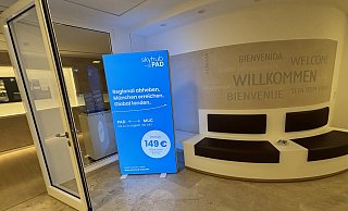 Die blaue Werbetafel der neuen Airline Skyhub PAD steht im Aufgang zum Sitzungssal des Kreishauses in der Paderborner Aldegreverstraße. - Jens Reddeker