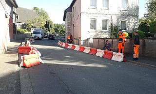 Die Hausecke (linke Seite) engt den Gehweg so ein, dass kein Kinderwagen oder Rollstuhl vorbeikommt. Das Foto entstand bei der Simulation der Gehwegverbreiterung. - Kreis Paderborn