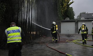 Die Feuerwehr löscht den Brand von Nadelbäumen an der Ackerstraße. - Tasja Klusmeyer