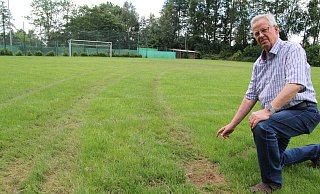 Heinz-Dieter Held ist zu Recht "sauer". Tiefe Reifenspuren ziehen sich durch den frisch renovierten Sportplatz. - Klaus Frensing