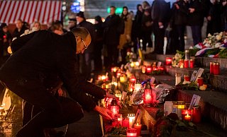 Menschen zünden bei der Gedenkveranstaltung zum Terroranschlag auf dem Berliner Breitscheidplatz an der Gedächtniskirche Kerzen an. - Christophe Gateau/dpa