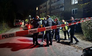 SEK und Bereitschaftspolizei verständigen sich vor dem Gebäude mit Vertretern von Feuerwehr und Rettungsdienst. - Paul Brinkmann