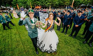 Die beiden Majestäten Dennis Happe und Stefanie Nötges ziehen bei der Parade auf dem Schützenplatz freudestrahlend an den Feuerwehr-Kollegen des Königs vorbei. - Besim Mazhiqi
