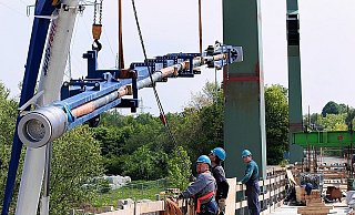 Das Seil, das 100.000 Euro pro Stück kostet, hängt in einem Spezialwerkzeug und wird von zwei Autokränen in Position gebracht. Die Arbeiter der Firma MCE Slany aus Tschechien steuern den Aufbau mit Handzeichen an die beiden Kranführer. - FOTO: ULF HANKE
