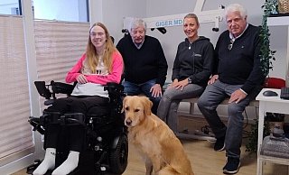Jana Schrautemeier und ihr Assistenzhund Lio freuen sich über die Spende vom Verein Hövelstein. Hermann Josef Hüser und Reinhard Berenbrinker (Hövelstein) sowie ihre Physiotherapeutin Sabrina Sens haben sie in ihrer Wohnung in Bielefeld besucht. - Hövelstein