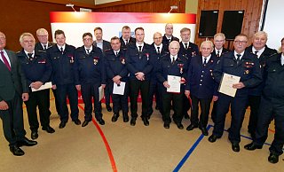 Vize-Landrat Hans-Bernd Janzen (l.), Bürgermeister Matthias Möllers (6. v. l.), Kreisbrandmeister Elmar Keuter (3. v. l.) und Wehrführer Rainer Hartmann (r.) gratulierten den Feuerwehrjubilaren zu ihren Auszeichnungen. - Ralph Meyer