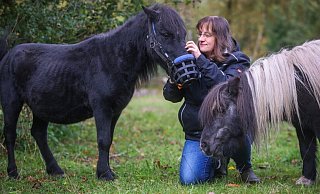 Drei, die sich mögen: das schwarze Shetlandpony Ätna, hier mit seinem Spezial-Maulkorb, Natalie Böger und Minihengst Timmy. - Sarah Jonek