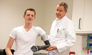 Unfallchirurg Thomas Vordemvenne überprüft den Sitz der bionischen Prothese von seinem Patienten Sven Roosen. Vordemvenne hatte Roosen vor zwei Jahren das Leben nach einem schweren Motorradunfall gerettet. - Oliver Krato