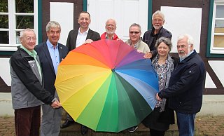 So bunt ist Brakel: Adalbert Grüner, Brakels Bürgermeister Hermann Temme, Thomas Rudolphi, Meinolf Schulte , Michael Fiekens, Rudolf Mönikes, Marion Benzait und Hans-Georg Harrer halten einen vielfarbigen Regenschirm als Symbol für Offenheit. - Alexander Graßhoff