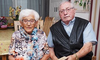 Gemeinsam blättern Maria und Herbert Jürs in seiner privaten, holzgefasster Vereinschronik. Die Fotos darin zeigen ihn im Karneval, als Fußballer, als Kommunalpolitiker und beim Papstempfang in Olsztyn (Allenstein). - Josef Köhne