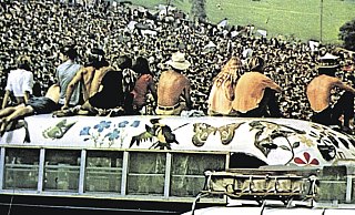Woodstock-Festivalbesucher haben das Dach eines der bemalten ehemaligen Schulbusse der „Hog Farm“-Kommune erklommen. - imago images