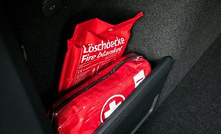 Eine Löschdecke ist wesentlich platzsparender als ein klassischer Feuerlöscher. Der Umgang damit sollte aber geübt werden. - Christin Klose/dpa-tmn