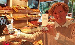 Friederike Tebbe, Geschäftsführerin der Konditorei und Bäckerei Welpinghus, präsentiert zwei der drei Möglichkeiten zum bargeldlosen Bezahlen: die geschäftseigene App und die Vorteilskarte. - Claus Meyer