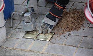 Künstler Gunter Demnig klopft in der Dr.-Neuhäußer-Strasse die beiden Stolpersteine fest, die an die Schwestern Emma und Berta Vorreuter erinnern sollen. - Elke Niedringhaus-Haasper