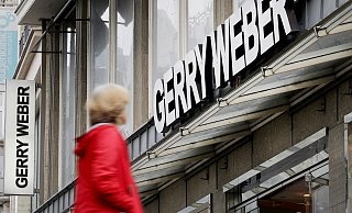 Eine Passantin geht an einer Filiale des Modeherstellers Gerry Weber vorbei. Der Konzern hat der Kette eine erneute Schrumpfkur verordnet. - dpa