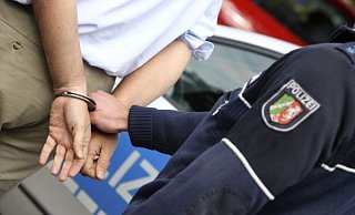 Ein Mann wird in Handschellen abgefuehrt. Symbolbild. - Jochen Tack