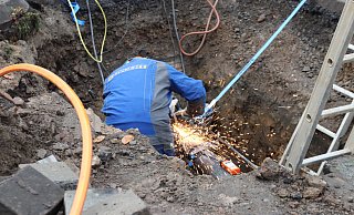 Ein Techniker arbeitet mit einer Flex an der defekten Gasleitung, die in der Straße "Am Mühlenbach" verläuft. - Dirk Windmöller