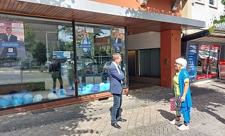 Im Gespräch mit dem Bürger, hier eine Bürgerin: Tobias Scherf vor seiner Wahlkampfzentrale an der Marktstraße in Warburg. - Dieter Scholz