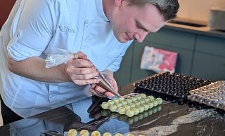 Nils Thiede aus dem Kreis Gütersloh füllt eine Ganache in die weißen Pralinen. Er liebt das Handwerkliche an seinem Beruf. "Man sieht, was man hergestellt hat und kann es vernaschen", sagt der 25-Jährige. - Privat