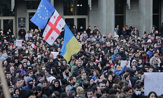 Demonstranten versammeln sich mit georgischen, ukrainischen und EU-Fahnen vor dem georgischen Parlamentsgebäude. - Zurab Tsertsvadze/AP/dpa
