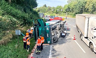 Die Feuerwehrmänner haben den auslaufenden Treibstoff gebunden und Polizisten inspizieren das Fahrwerk des Sattelzugs. - LA Hillegossen