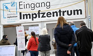 Impfwillige stehen vor dem Eingang des Impfzentrums in Rosenheim. - Foto: Peter Kneffel/dpa