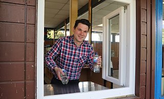 Den Kiosk im Freibad Elverdissen betreibt in dieser Saison die Schaustellerfamilie Kaiser. Maurice Kaiser hatte die Idee zum Ausgabefenster, damit die Besucher ganz schnell an Wasser, Eis und Pommes kommen. - Susanne Barth