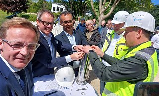 Staatssekretär Daniel Sieveke (v. l.) schaut genau hin, wie Stadtwerke-Chef Leander Sasse, Architekt Thomas Kalman, Albrecht Schaeffer, Projektleiter bei den Stadtwerken und Bäderleiter Thorsten Müller die Zeitkapsel füllen und verschließen. Nur für einen kurzen Moment lässt er sich ablenken. - Dieter Scholz