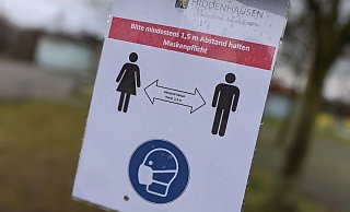 Ein Schild erinnert vor der Olof-Palme-Gesamtschule an die Einhaltung von Maskenpflicht und Abstandsgebot. - David Knapp
