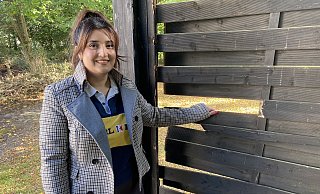 Ayfer Özdogan steht an der Holzwand, an der die Bretter herausgeschlagen oder -getreten wurden. - Dirk Windmöller Ayfer Özdogan steht an der Holzwand, an der die Bretter herausgeschlagen oder -getreten wurden. - Dirk Windmöller