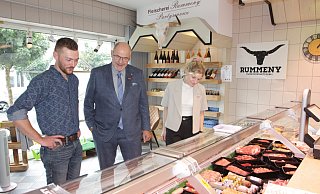 Fleischermeister Nils Wüllner zeigt Peter Eul, Präsident der Handwerkskammer OWL, und Lisa Büngeler, Betriebsberaterin der Handwerkskammer, seine Produkte in der Bad Lippspringer Metzgerei Rummeny. - Uwe Müller