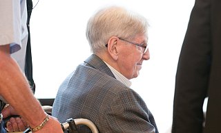 In Detmold: Der Angeklagte Reinhold Hanning wird mit einem Rollstuhl in den Verhandlungssaal gefahren. - dpa