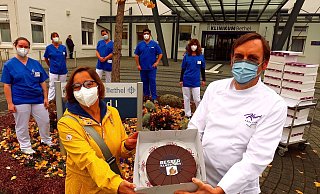 Vor dem EvKB überreichte Jörg Kraume eine Torte an Pflegerin Beate Mörchen. - Kurt Ehmke