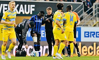 SCP-Angreifer Sirlord Conteh muss in der 67. Minute verletzt vom Platz. Physiotherapeut Jörg Liebeck (l.) und Mannschaftsarzt Lutz Mahlke haben ihm bereits eine Oberschenkel-Bandage verpasst. - Besim Mazhiqi