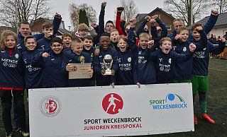 Die D-Junioren des FC Gütersloh bejubeln den Sieg im Kreispokal-Finale gegen den SC Wiedenbrück. Doppeltorschütze Joshua Oghie präsentiert den Pokal. - Uwe Caspar