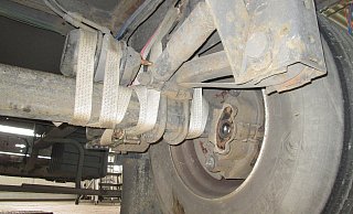 Die defekte Achse des Sattelaufliegers wurde nur noch über Spanngurte gehalten. - Autobahnpolizei