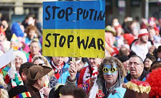 Protestplakat gegen den Krieg beim Kölner Straßenkarneval. - Foto: Oliver Berg/dpa