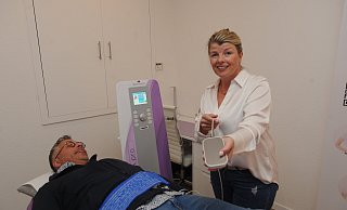 Anja-Bianca und Torsten Reimler haben in Rahden ein "Abnehmen im Liegen"-Studio eröffnet. Pads wie das, das Anja-Bianca Reimler zeigt, arbeiten mit Wärme und Reizstrom. - Joern Spreen-Ledebur
