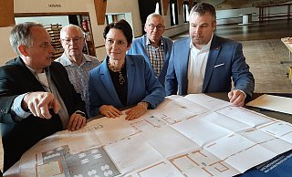 Der Blick nach vorn: Andre Volmary (v. l.), Vorsitzender der Daseburger Vereinsgemeinschaft, Landesministerin Silke Gorißen und Bezirksverwaltungsstellenleiter Thomas Klenke. Hermann-Josef Ewe von der Rentner AG und Günter Thill vom VdK schauen ihnen über die Schulter. Auf dem Tisch liegt der Bauplan. - Dieter Scholz